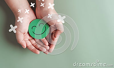 Hands holding green happy smile face, good feedback rating, positive customer review, experience, satisfaction survey, smiley Stock Photo