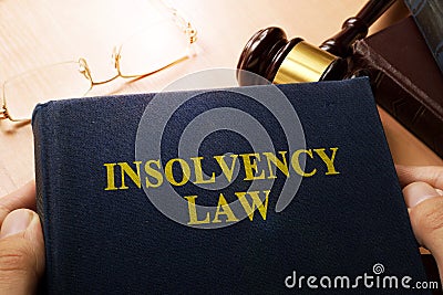 Hands holding insolvency law. Stock Photo