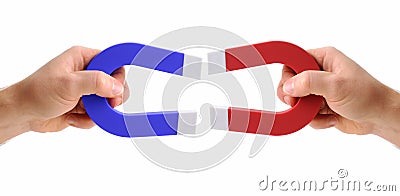 Hands holding magnets one red and one blue Stock Photo