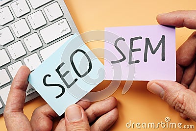 Hands holding cards with SEO and SEM Stock Photo