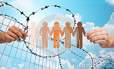 Hands holding people pictogram over barb wire Stock Photo