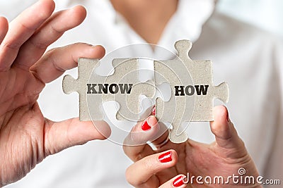 Hands Holding Puzzle Pieces for Know How Concept Stock Photo