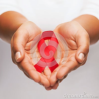 Hands holding red AIDS awareness ribbon Stock Photo