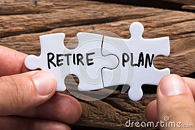 Hands Holding Retire Plan Matching Jigsaw Pieces Stock Photo