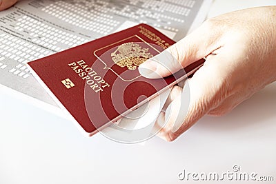 Hands holding russian passport and registration at the place of stay form Stock Photo