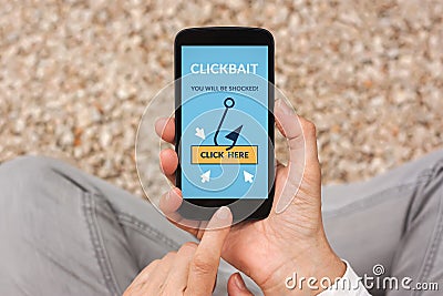 Hands holding smart phone with clickbait concept on screen Stock Photo