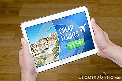 Hands holding tablet with cheap flghts for sale add on internet. Stock Photo