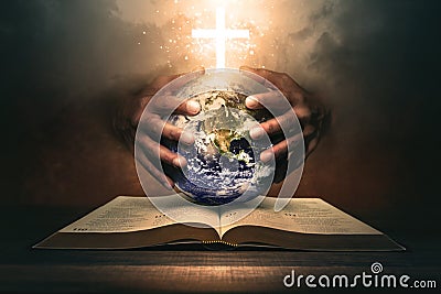 Hands holding the world on a Holy Bible Stock Photo