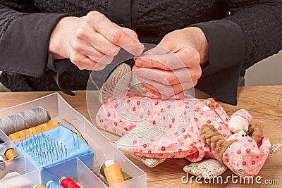 Hands inserting thread a needle Stock Photo