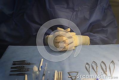 hands of an instrumentalist nurse prepared on a blue sterile field and surgical material for an ophthalmologic retinal surgery Stock Photo