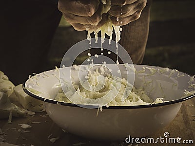 Hands kneading sauerkraut - salty cabbage juice is dripping down Stock Photo