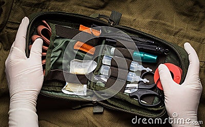 Hands in latex gloves opening a first aid kit. First aid in an emergency Stock Photo