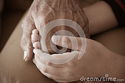 Hands of little Asian kids holding poor elderly grandfather man hands wrinkled skin with feeling care and Love. Father`s Day and Stock Photo