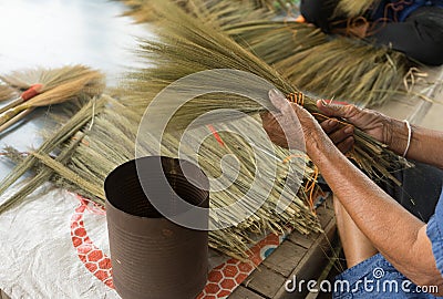 Hands made a broom from dry grass flower. Stock Photo