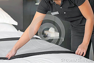 Hands of Maid Making Bed. Housekeeper Making Bed Stock Photo