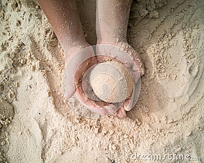 Hands making sphere sand ball by a child at the beach. Play sand Stock Photo