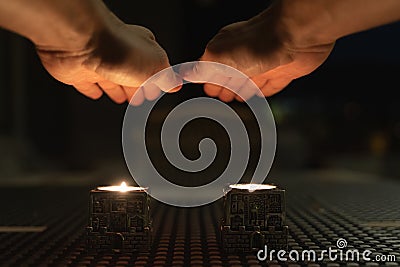 Hands of man above candles praying for popular Shabbat meal Stock Photo