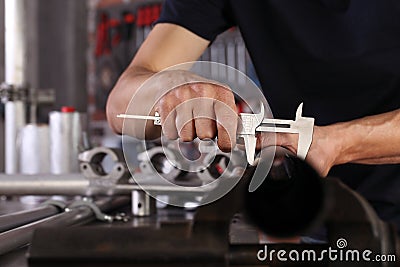 Hands man closeup work in home workshop garage with caliper measure metal pipe fixed to the vise on the work bench, diy and craft Stock Photo