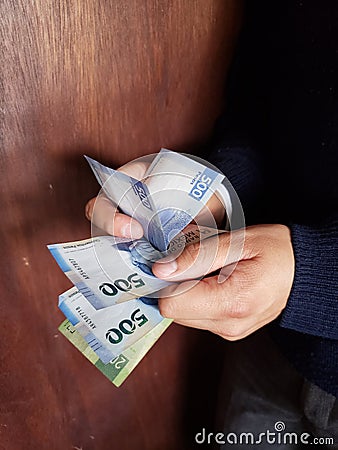 hands of a man counting Mexican banknotes Stock Photo