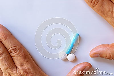 Hands of a man next to pills that symbolize a penis with an erection. Metaphor of male virility. Medicine related to male Stock Photo