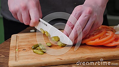 Hands slicing cucumber and tomato on the cutting board. Stock Photo