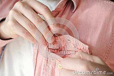 Hands of a man who took off a golden wedding ring and puts it in shirt pocket to hide his marital status from mistress. Stock Photo