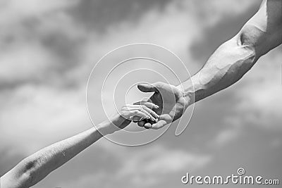 Hands of man and woman on blue sky background. Lending a helping hand. Solidarity, compassion, and charity, rescue Stock Photo