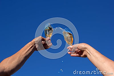 Hands of man and woman clink wineglasses of sparkling white wine Stock Photo