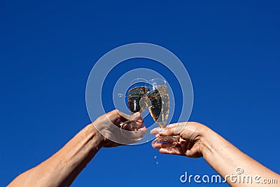 Hands of man and woman clink wineglasses of sparkling white wine Stock Photo