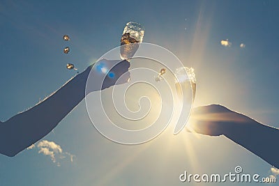 Hands of man and woman clink wineglasses of sparkling white wine Stock Photo