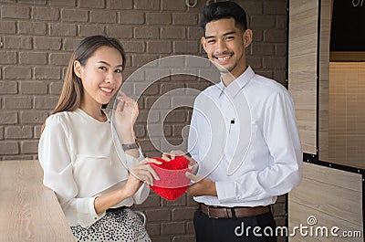 Hands of man and woman holding red heart protecting it together Stock Photo