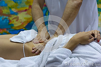 Hands of the masseur and the client`s body during massage treatm Stock Photo