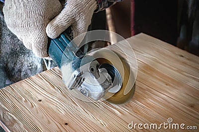 Hands of the master a drill and a brush clean wood and give it texture. The process of Brushing wood. Copy space Stock Photo