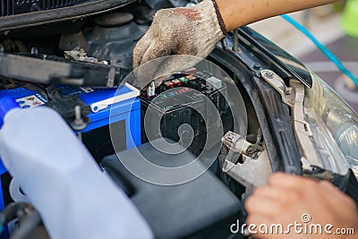 The hands of the mechanic replacing the fuse in the car. The mechanic selects the correct fuse. selective focus Stock Photo