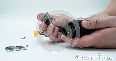 The hands of men dismantled the machine clipper repair clippers and hair Stock Photo