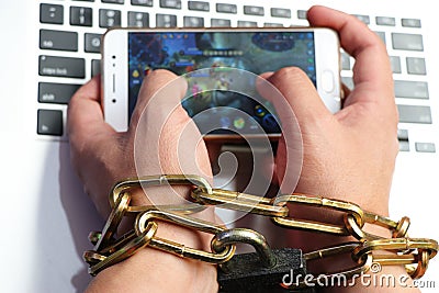 A computer is tied to a man`s hand by a sturdy chain. Stock Photo