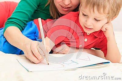 Hands of mother and child writing letters Stock Photo