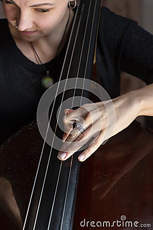 Hands of a musician playing on a contrabass closeup Stock Photo