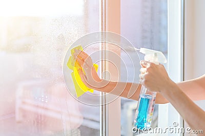 Hands with napkin cleaning window. Washing the glass on the windows with cleaning spray. Stock Photo