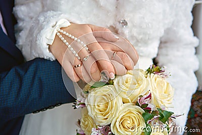 Hands newlyweds with a bouquet. Bouquet of white roses Stock Photo