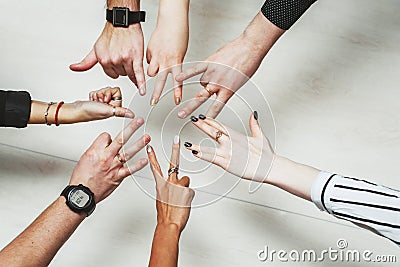 Hands of office workers in a circle. Different gestures of young people. Thumb up, peace sign and other signs Stock Photo