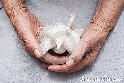 Hands of an old woman holding Christmas toy hearts. Merry christmas and happy new year idea. Stock Photo