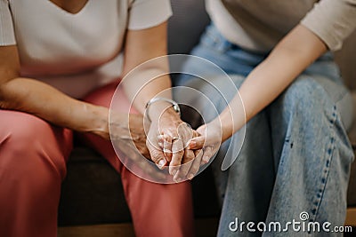Hands of the old woman and a wman hand in home Stock Photo