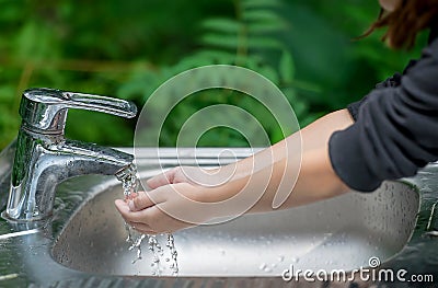 Hands open for drinking tap water. Pouring fresh healthy drink. Good habit. Right choice. Child washes his hand under the faucet Stock Photo