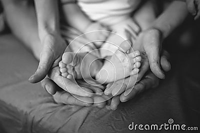 hands of parents concerned barefoot baby Stock Photo