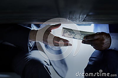 Hands passing money under table corruption bribery Stock Photo