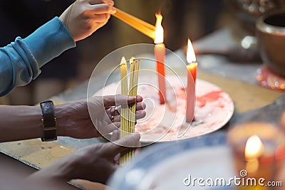 Hands of a person with a bunch of thin candles Stock Photo