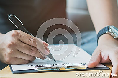 Hands of person filling application form or writing personal information in contract Stock Photo