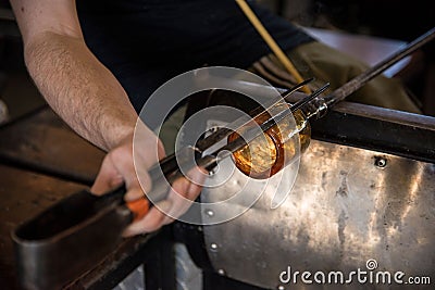 Hands of a person glass blowing in the workshop Stock Photo