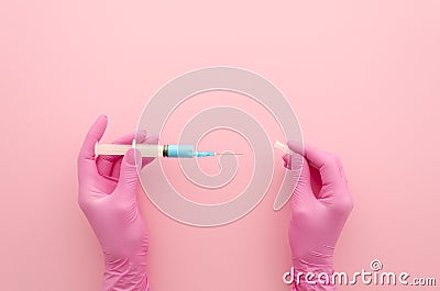 Hands in pink glove with syringe injection on pink. Medical concept. Top view mock up Stock Photo